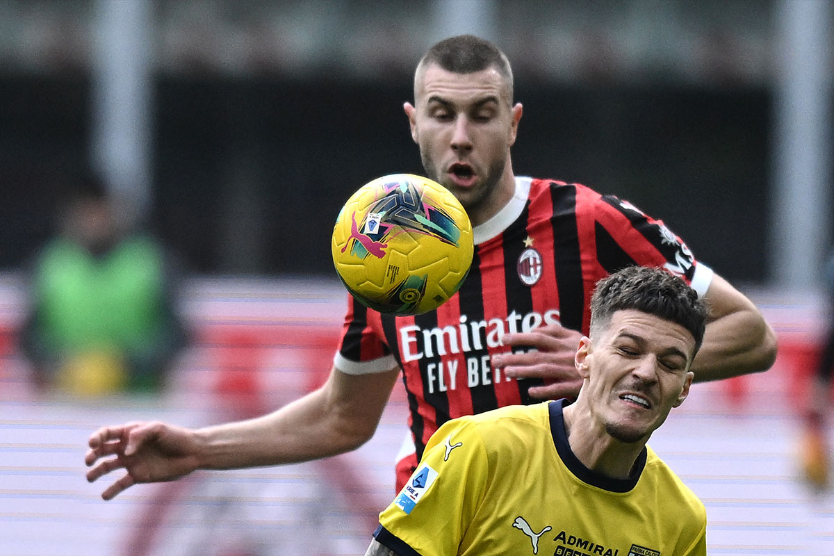 Dennis Man del Parma reagisce con una smorfia di dolore dopo uno scontro con Strahinja Pavlovic del Milan, partita Milan-Parma del 26 gennaio 2025.