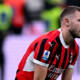 Strahinja Pavlovic in ginocchio sul campo, visibilmente frustrato, dopo l’ennesimo gol subito dal Milan durante una partita di Serie A.